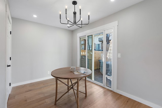 dining room with light hardwood / wood-style floors and a notable chandelier