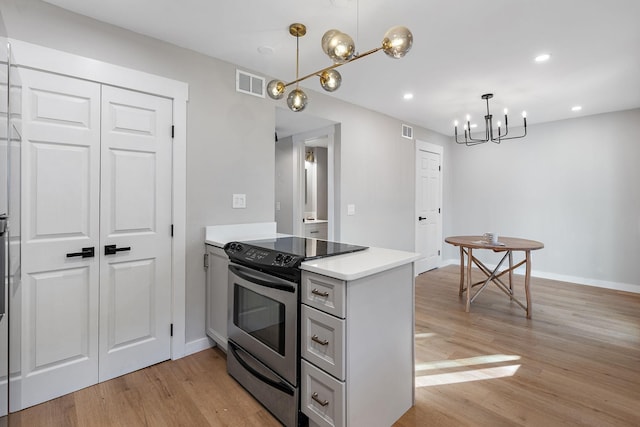 kitchen featuring a chandelier, light hardwood / wood-style flooring, electric range, and decorative light fixtures