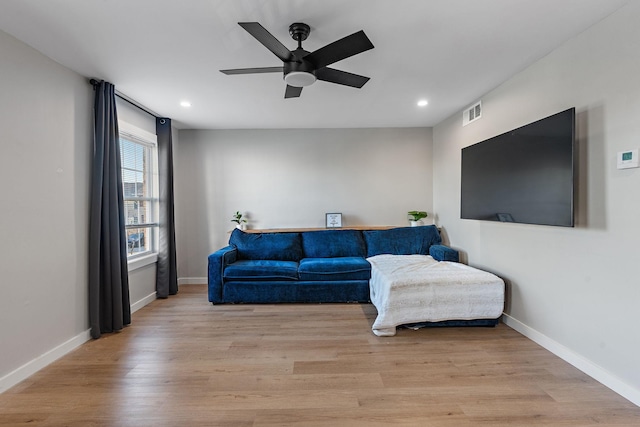 living room featuring ceiling fan and light hardwood / wood-style flooring