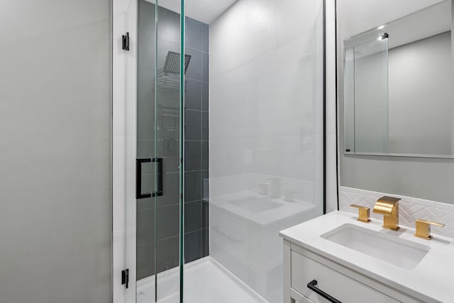 bathroom with a shower with shower door and vanity