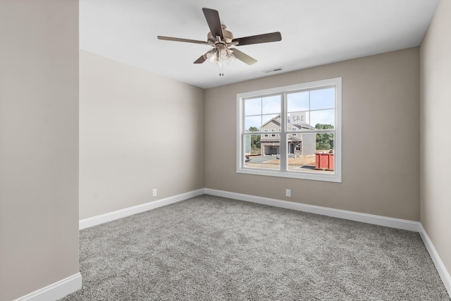 carpeted spare room featuring ceiling fan