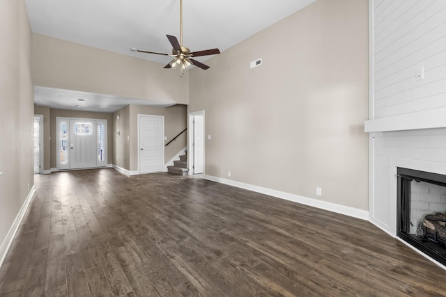 unfurnished living room with ceiling fan, a large fireplace, dark hardwood / wood-style floors, and high vaulted ceiling