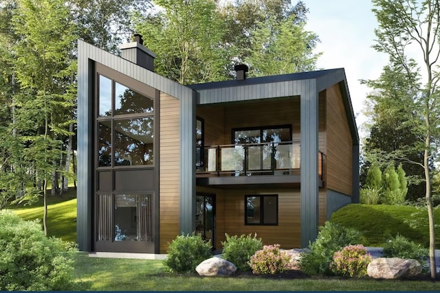 rear view of house with a lawn and a balcony