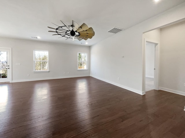 spare room with ceiling fan, dark wood-type flooring, and a wealth of natural light