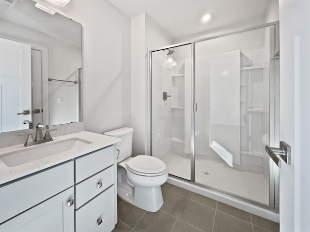 bathroom with an enclosed shower, vanity, tile patterned flooring, and toilet