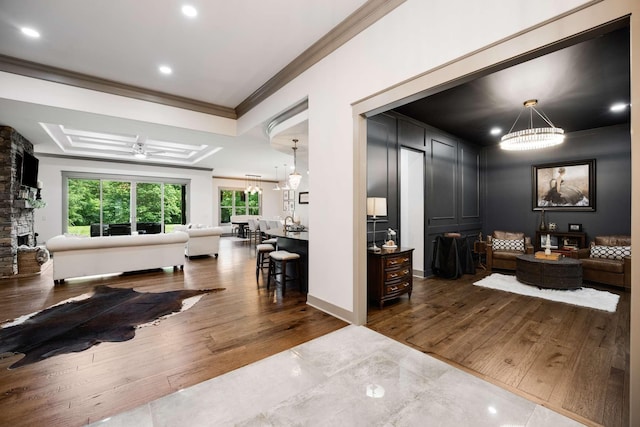 interior space featuring an inviting chandelier, crown molding, and hardwood / wood-style floors