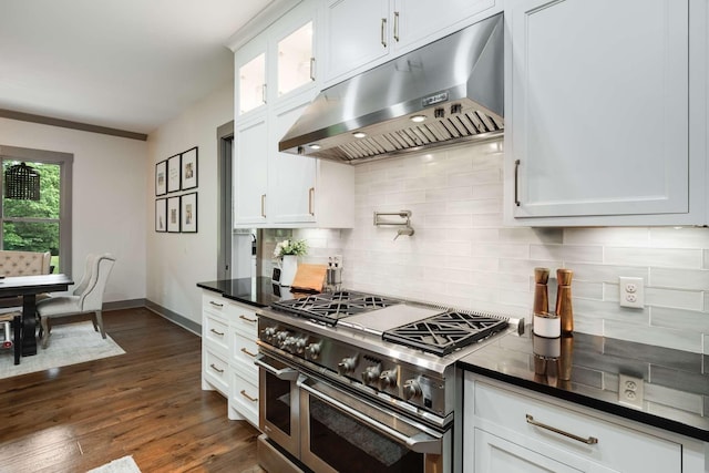 kitchen with dark wood-type flooring, double oven range, white cabinetry, and tasteful backsplash