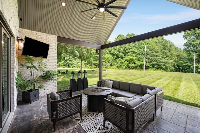 view of patio with ceiling fan and an outdoor living space with a fire pit