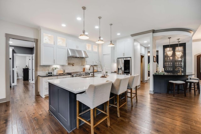 kitchen with white cabinetry, tasteful backsplash, decorative light fixtures, and sink