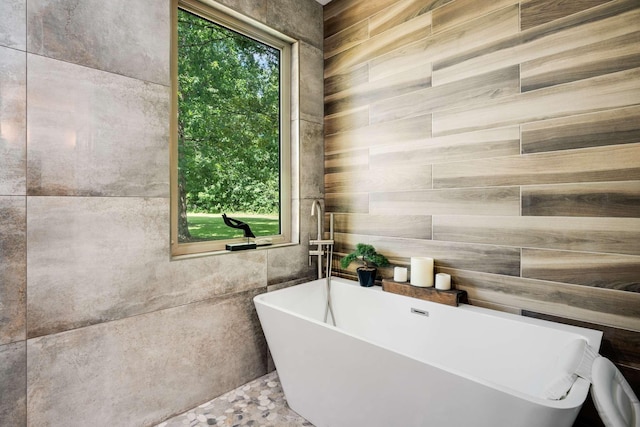 bathroom featuring a bathing tub and tile walls