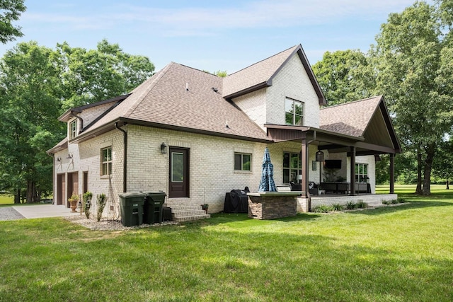 back of property featuring a garage and a lawn