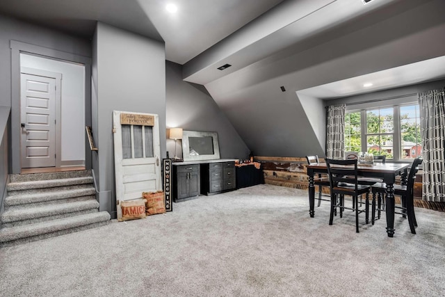 dining area with carpet and vaulted ceiling