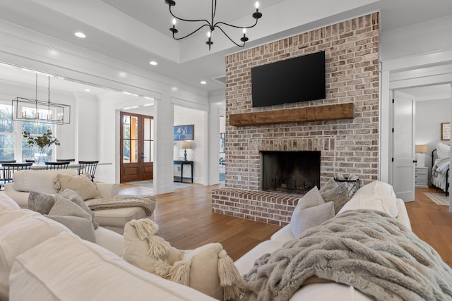 living room with a brick fireplace and hardwood / wood-style floors