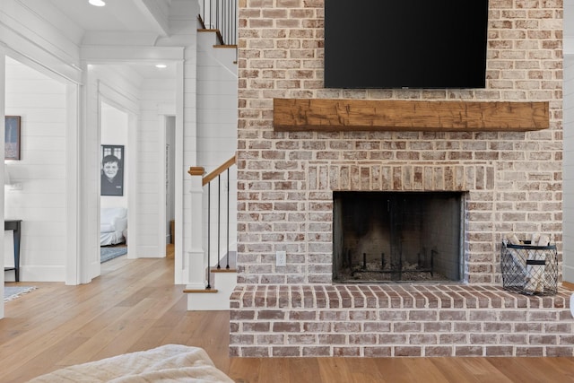 living room with light wood-type flooring and a brick fireplace