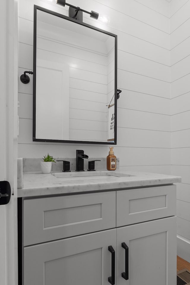 bathroom with wooden walls and vanity