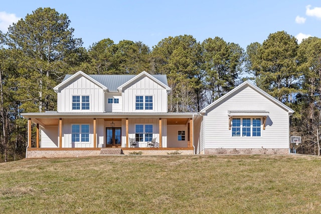 modern farmhouse style home featuring covered porch and a front lawn