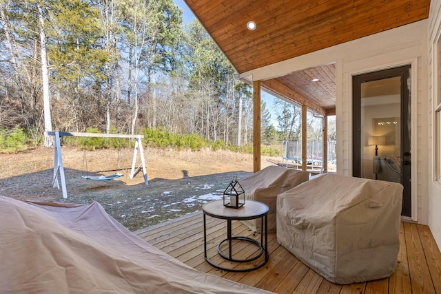 deck featuring a trampoline and area for grilling