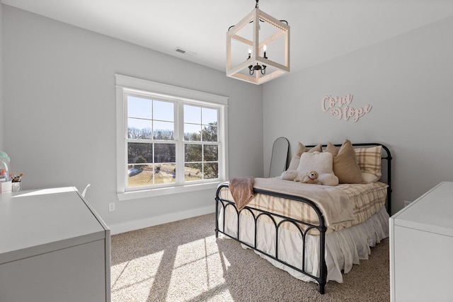 carpeted bedroom featuring an inviting chandelier