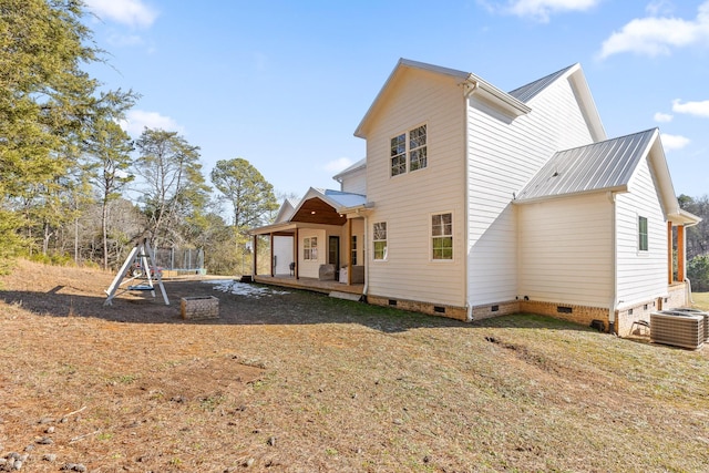 back of property featuring central AC unit and a trampoline