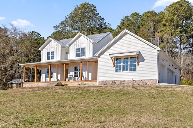 view of front of house with a front yard, a porch, and a garage