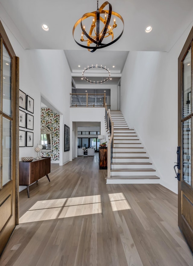 foyer with light hardwood / wood-style flooring and an inviting chandelier