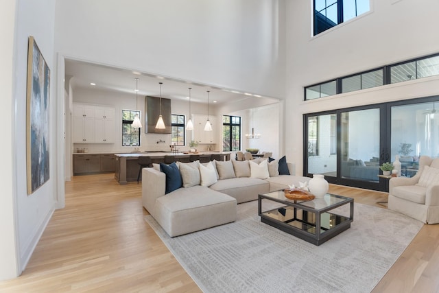 living room featuring light wood-type flooring and a high ceiling