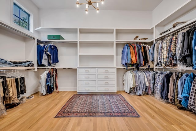 spacious closet featuring hardwood / wood-style flooring and a notable chandelier