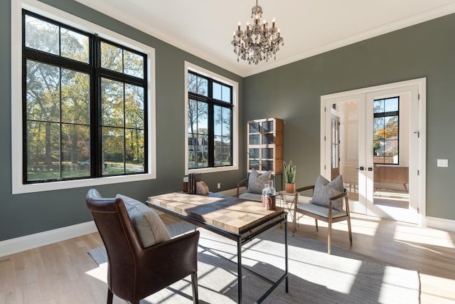 home office with an inviting chandelier, a healthy amount of sunlight, light hardwood / wood-style floors, and french doors