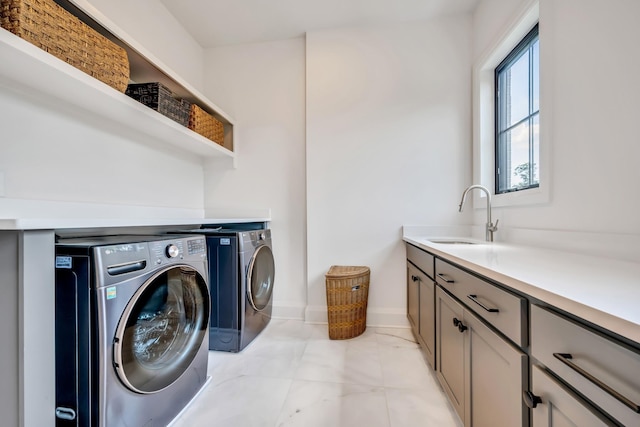 washroom with cabinets, sink, and independent washer and dryer