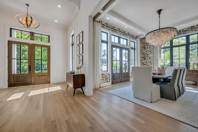 dining space featuring an inviting chandelier, light hardwood / wood-style flooring, and french doors