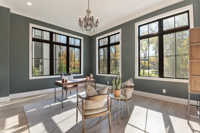 sitting room with light wood-type flooring, a chandelier, and ornamental molding