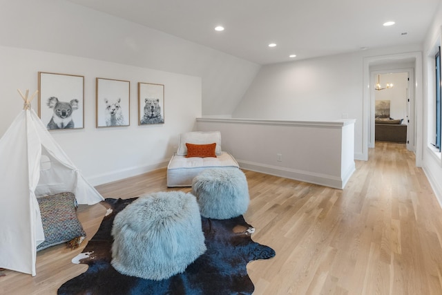 living area featuring lofted ceiling and light hardwood / wood-style floors