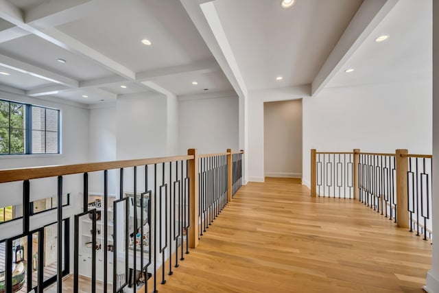 corridor with light wood-type flooring, beamed ceiling, and coffered ceiling