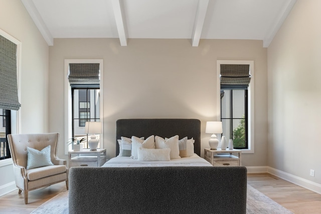 bedroom featuring light hardwood / wood-style floors and beam ceiling