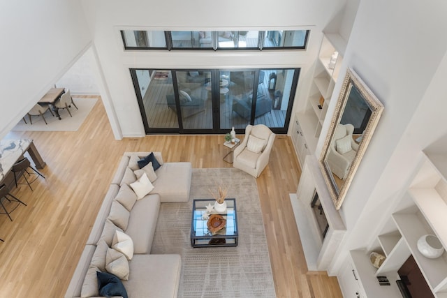 living room with a towering ceiling and hardwood / wood-style flooring