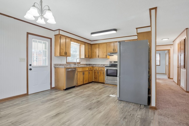 kitchen featuring appliances with stainless steel finishes, decorative light fixtures, sink, ornamental molding, and light wood-type flooring