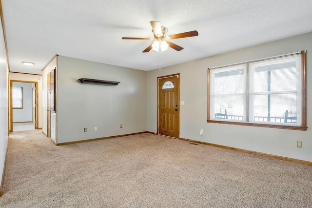 unfurnished room featuring ceiling fan, light colored carpet, and a textured ceiling