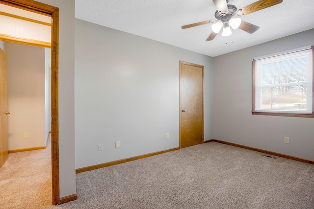 unfurnished bedroom featuring light colored carpet and ceiling fan