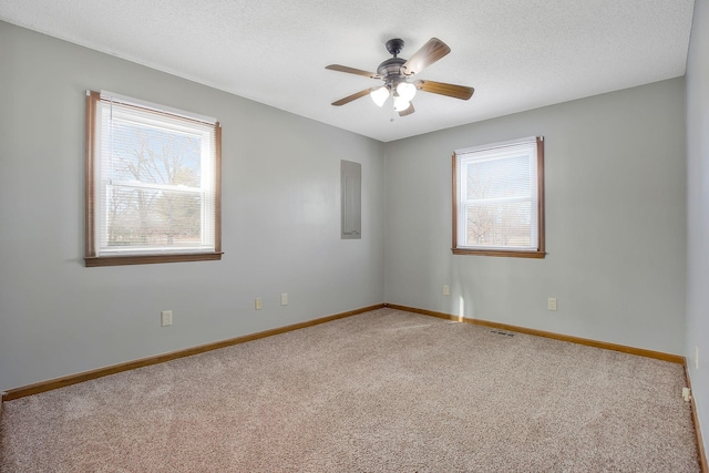 carpeted empty room with ceiling fan and a textured ceiling