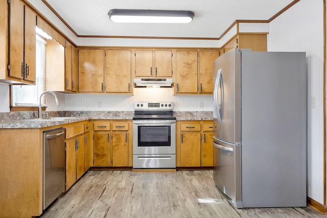 kitchen with ornamental molding, stainless steel appliances, sink, and light hardwood / wood-style flooring