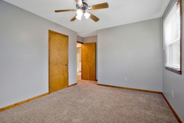 spare room featuring ceiling fan and carpet