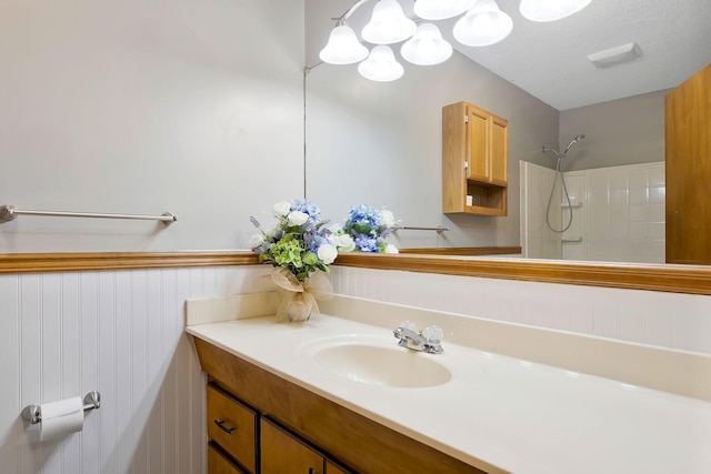 bathroom with vanity and tiled shower