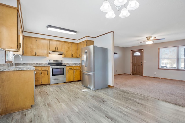 kitchen with sink, ceiling fan with notable chandelier, stainless steel appliances, and light hardwood / wood-style floors