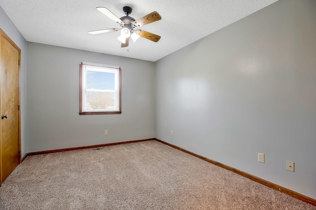 carpeted spare room with ceiling fan and a textured ceiling