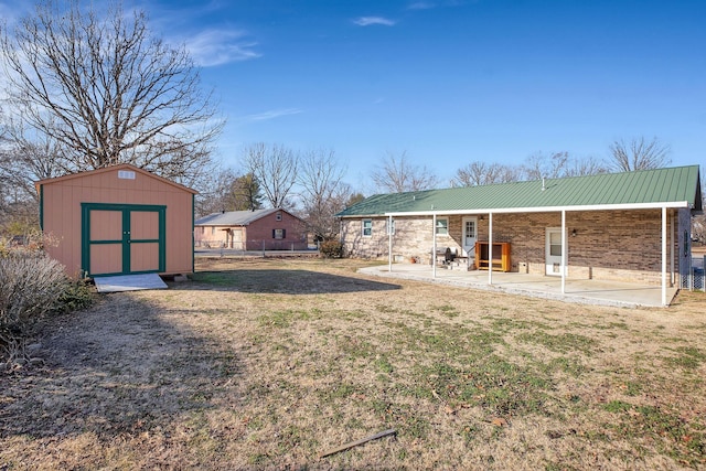 view of yard featuring a storage unit and a patio