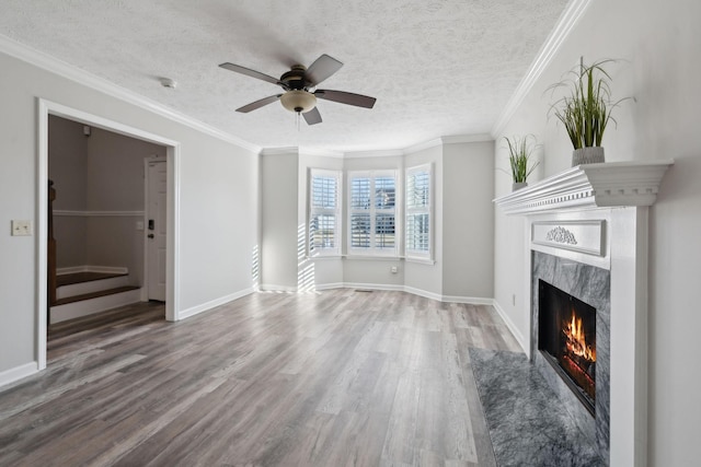 unfurnished living room with hardwood / wood-style flooring, ceiling fan, a fireplace, a textured ceiling, and crown molding