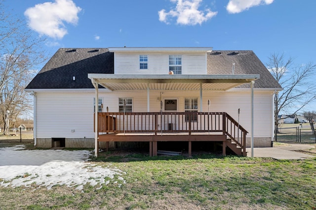 back of property with a deck and a lawn