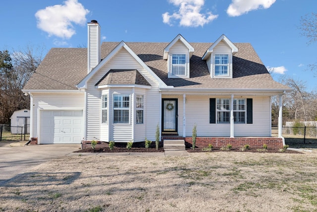 new england style home featuring a front yard and a garage