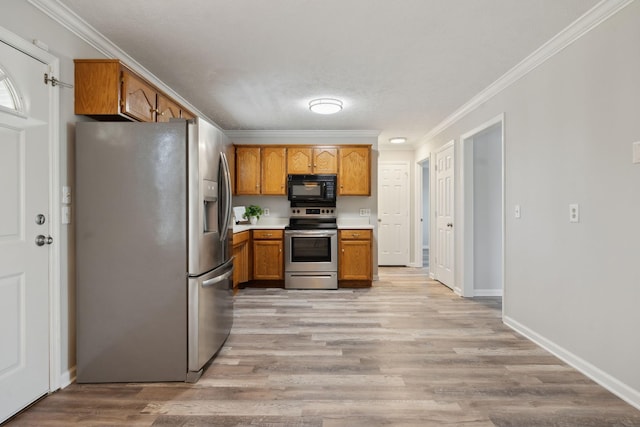 kitchen with a textured ceiling, stainless steel appliances, crown molding, and light wood-type flooring