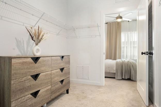 walk in closet featuring light carpet and ceiling fan